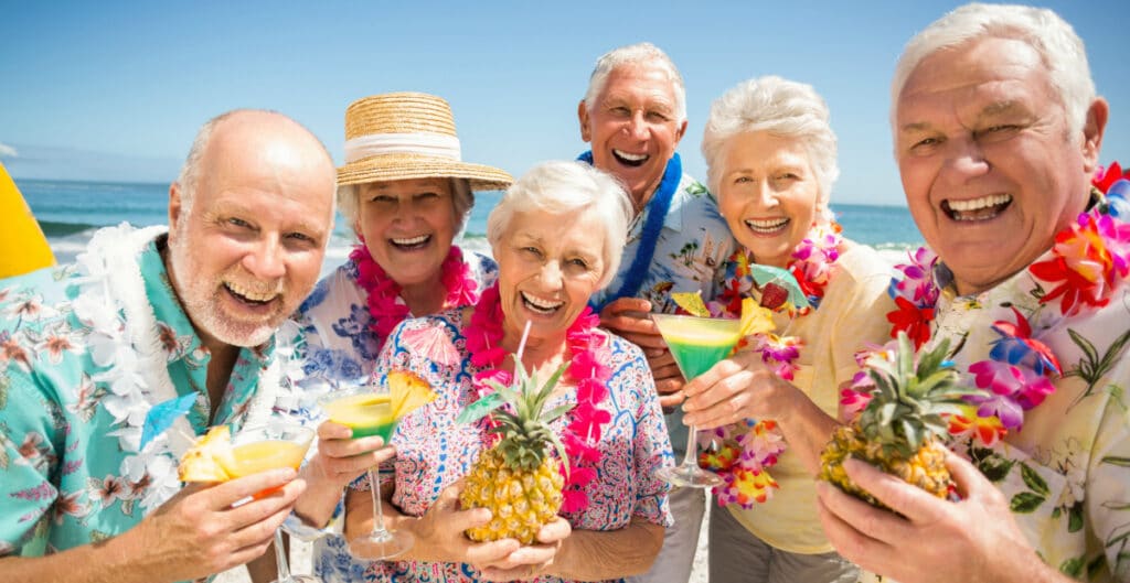 a group of senior citizen friends on a beach with drinks