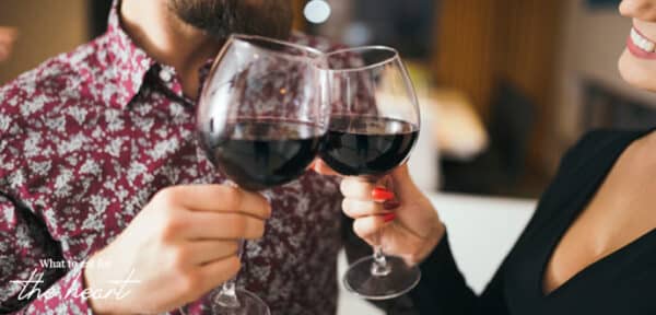 a man and women clinking their wine glasses together