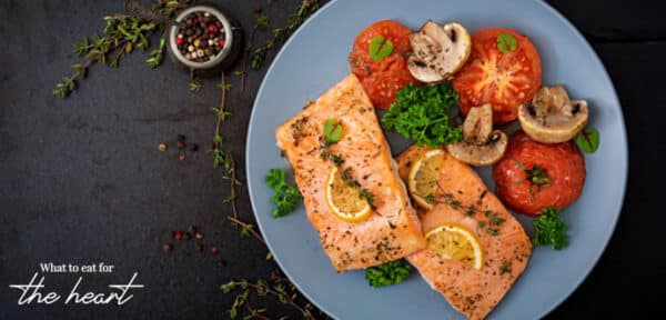 Cooked salmon on a plate with mushroom and tomatoes