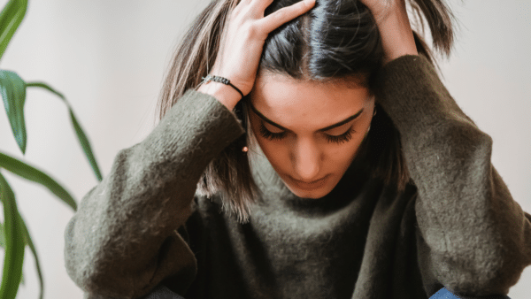 a women kneeling down with her hands in her hair